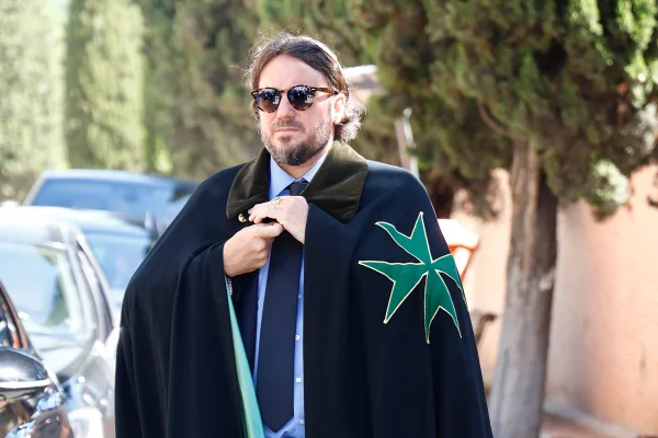 Na foto Francisco de Borbón von Hardenberg aparece vestindo uma capa preta da realeza por cima de um terno