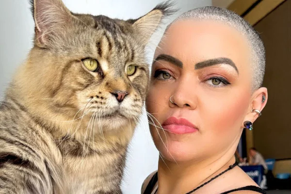 Foto colorida de uma mulher e um gato - Metrópoles