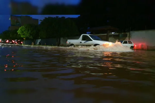 carro passando por rua alagada