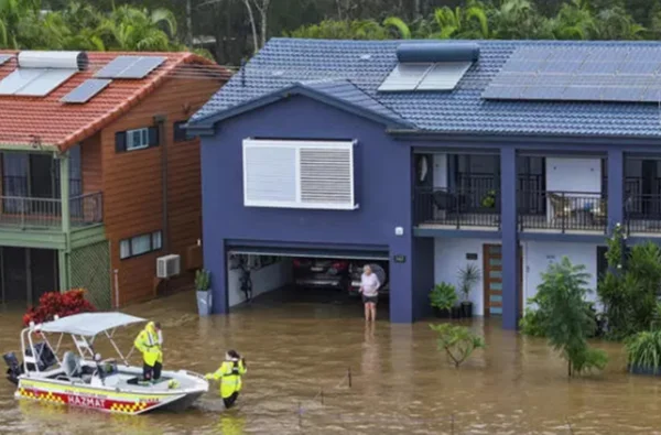 Mulher sendo resgatada após filhar ilhada pelas enchentes na Austrália