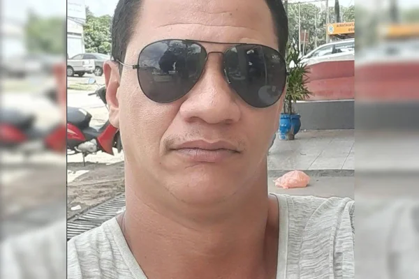 Foto colorida de homem branco com cabelo curto e óculos escuro