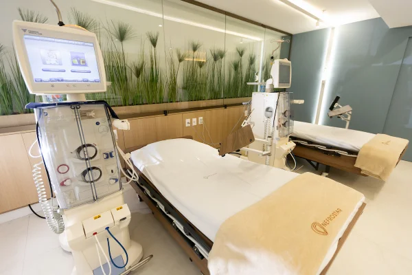 Fotografia de sala de hemodiálise, mostrando cadeiras reclináveis alinhadas e máquinas modernas