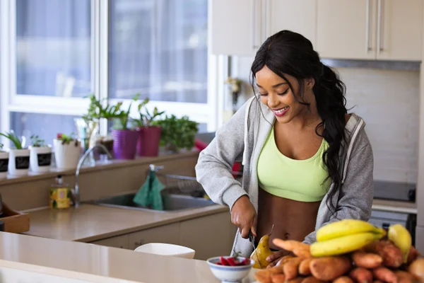 mulher jovem preparando refeição em cozinha
