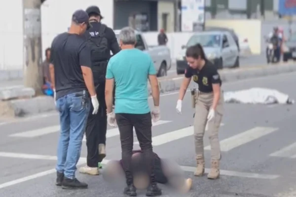 Policiais ao redor de um corpo
