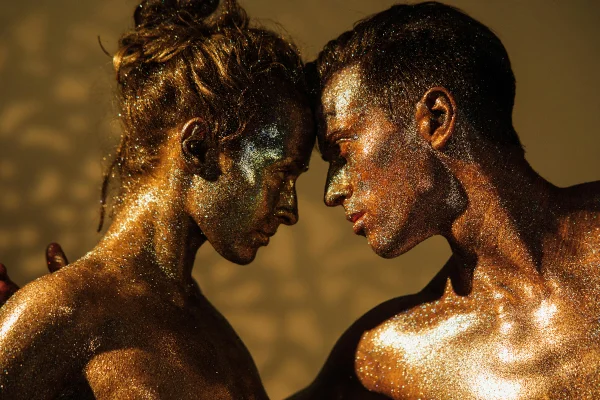 imagem de duas pessoas coberta de glitter dourado