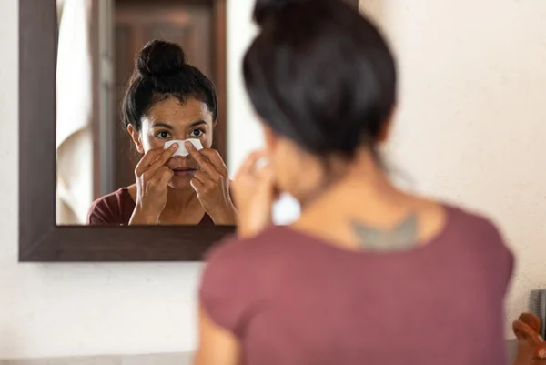 Mulher com pedaço de papel no nariz com acne - Metrópoles