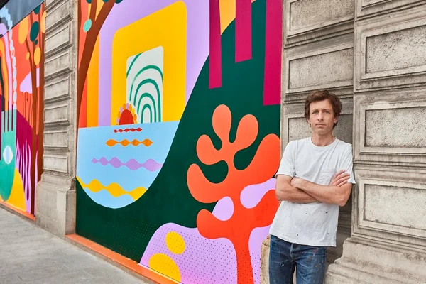 artista com painel de pinturas