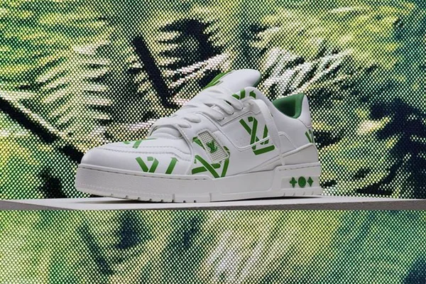 Modelo de tênis da marca francesa Louis Vuitton. A peça é toda branca com a logo marca impressa em verde