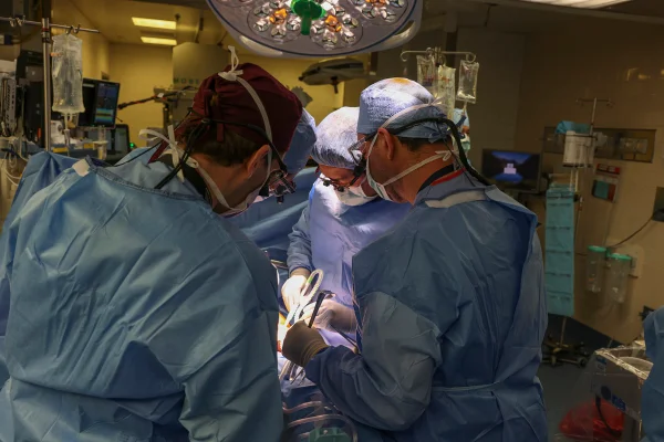 Foto mostra equipe médica paramentada em sala de cirurgia para transplante