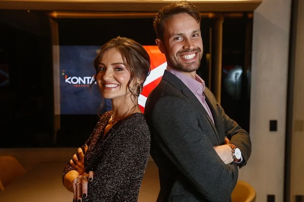 Fotografia colorida de um homem e uma mulher com a logo da Kontá Imoveis atrás