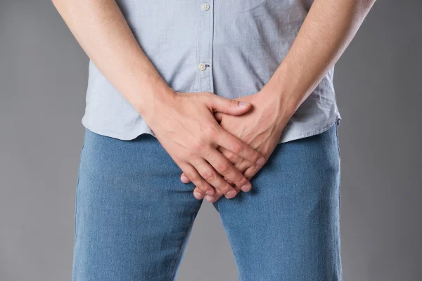 Dor na próstata, homem sofrendo de prostatite ou doença venérea, foto de estúdio em fundo cinza. Metrópoles