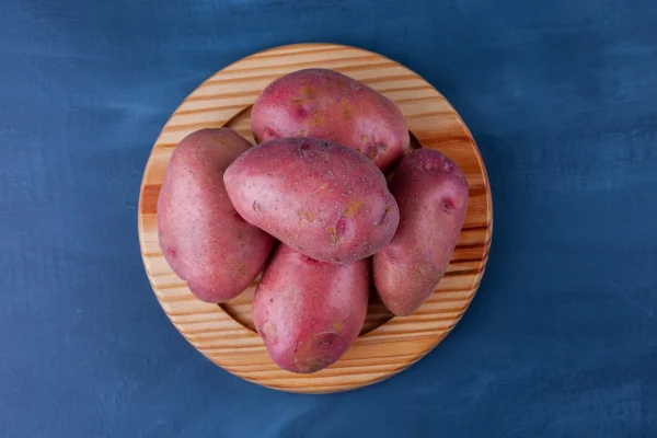 Batatas doces empilhadas em bandeja de madeira
