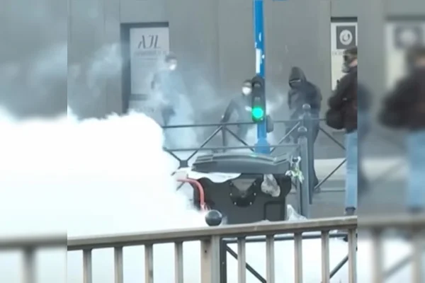 Imagem colorida de polícia disparando gás lacrimogêneo contra manifestantes