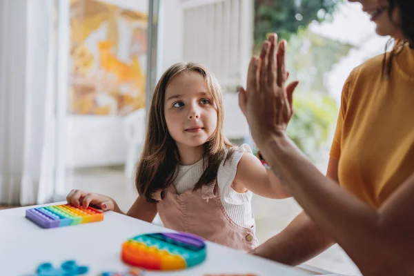 mãe brincando com filha autista. Autismo. Metrópoles