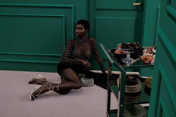 Mulher com roupa de festa sentada no chão da sala | Metrópoles