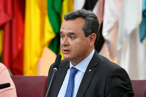 Fotografia colorida de homem de terno discursando em microfone