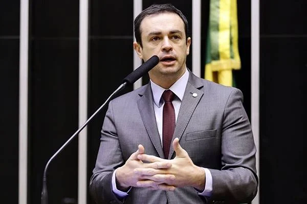 Fotografia colorida de homem de terno falando em microfone