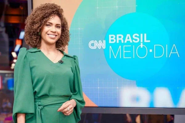 Mulher de cabelo encaracolado e vestido verde - Metrópoles