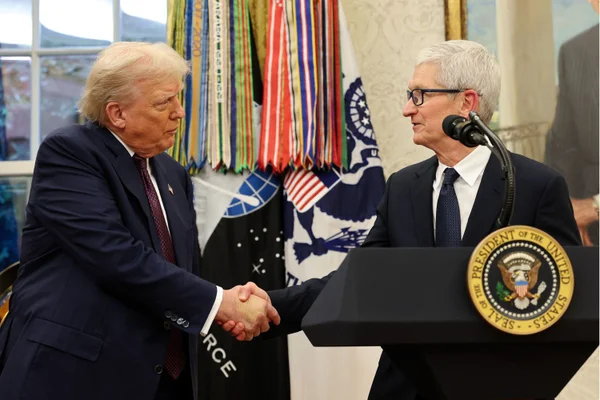 Foto colorida do presidente Donald Trump apertando a mão do CEO da Apple, Tim Cook - Metrópoles