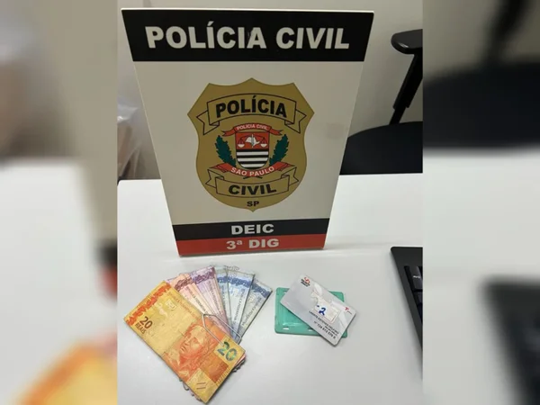 Imagem de placa da Polícia Civil com cédulas de reais e bilhete de transporte - Metrópoles