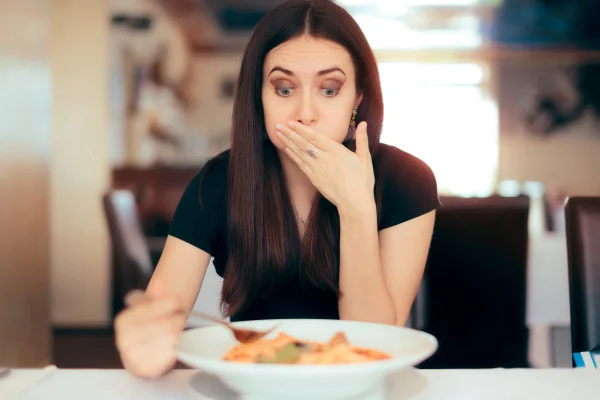 Foto colorida de uma mulher comendo - Metrópoles