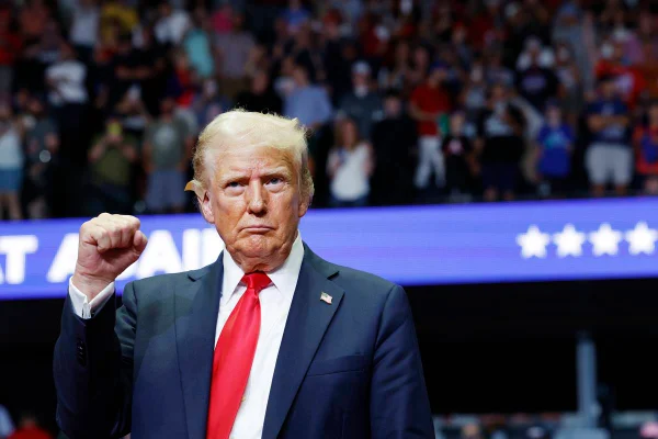 Imagem colorida mostra Donald Trump com o braço levantado e punho cerrado - Metrópoles
