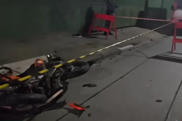 Imagem colorida de uma motocicleta deitada no asfalto após ser atingida por um caminhão, cujo motorista fugia de assalto - Metrópoles