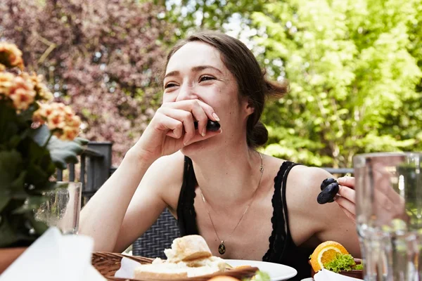 Mulher jovem comendo uvas - Metrópoles
