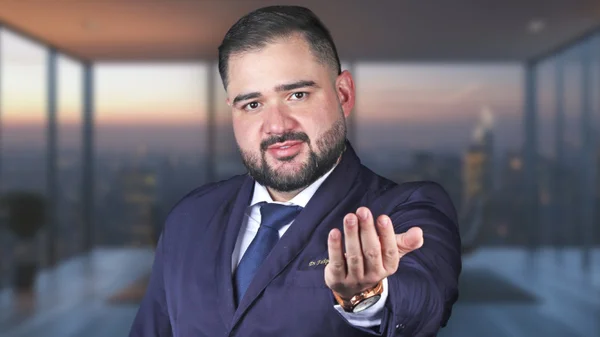 Fotografia colorida mostrando homem de terno chamando com uma mão-Metrópoles