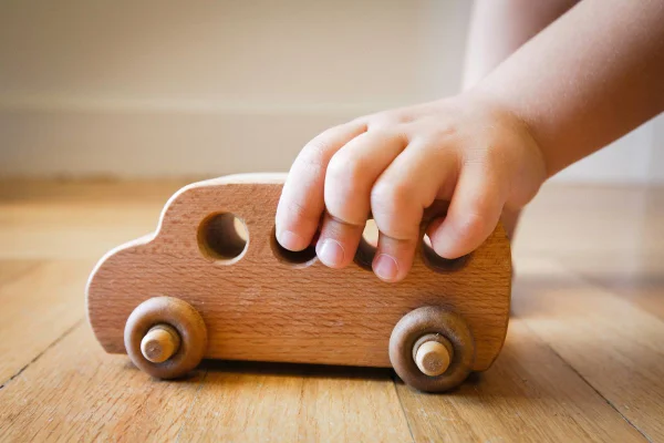Foto colorida de criança branca brincando com carrinho de brinquedo. Imagem ilustrativa - Metrópoles