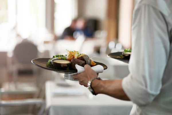 Foto colorida de um homem com prato de comida na mão - Metrópoles