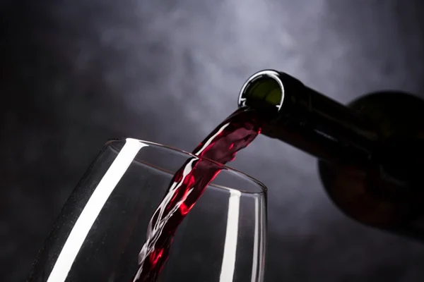 Garrafa derramando vinho em taça