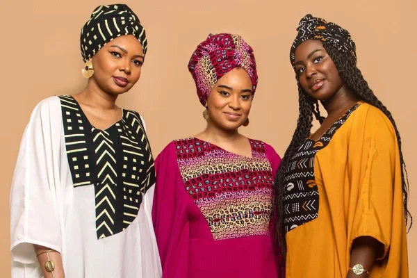 Três mulheres negras usam roupas coloridas com estampas africanas e turbantes - Metrópoles