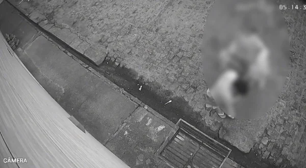 Imagem em preto e branco de momento em que carregam corpo de homem - Metrópoles
