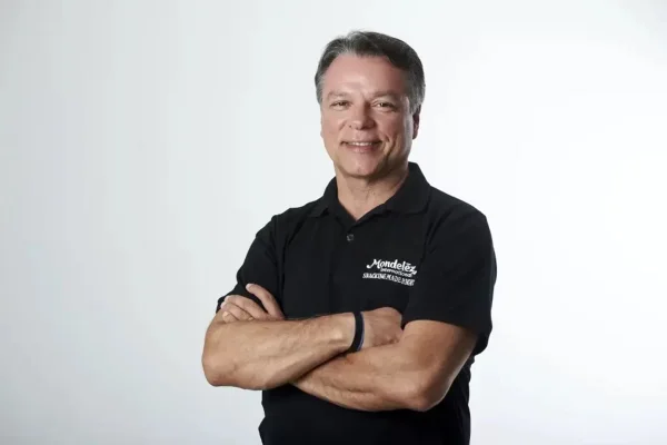 Imagem de Liel Miranda, novo CEO da Alpargatas, em foto posada. Ele está de braços cruzados, sorri e veste uma camiseta preta - Metrópoles