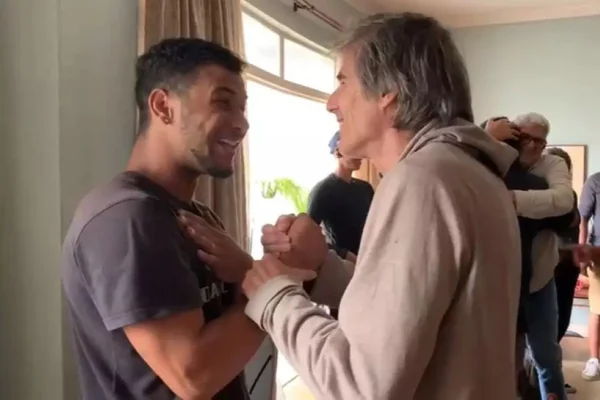 Imagem colorida de um jovem à esquerda e o diretor Walter Salles à direita, na filmagem de Ainda Estou Aqui