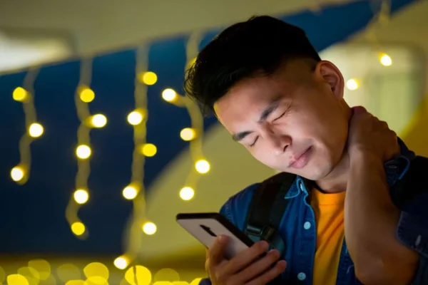 Homem mexendo no celular e sentindo dor no pescoço - Metrópoles - diagnosticar ansiedade
