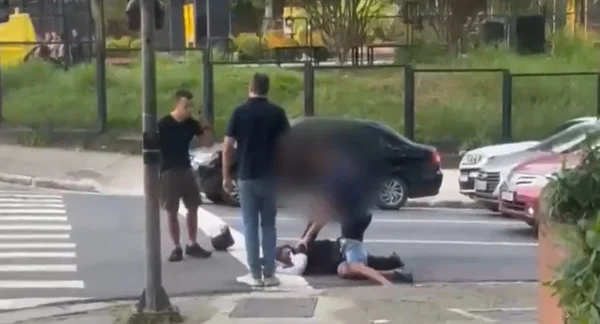 imagem colorida mostra policial imobilizando suspeito de arrastão em rua de são paulo - metrópoles