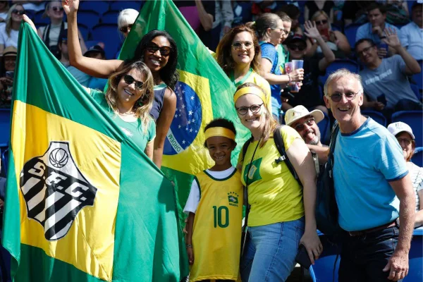 Torcida vestindo cores da bandeira do Brasil em estádio de futebol