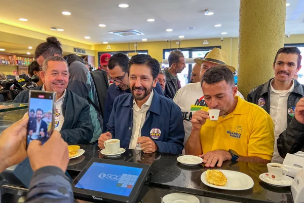 Imagem colorida mostra Ricardo Nunes e Coronel Mello Araujo em padaria - Metrópoles