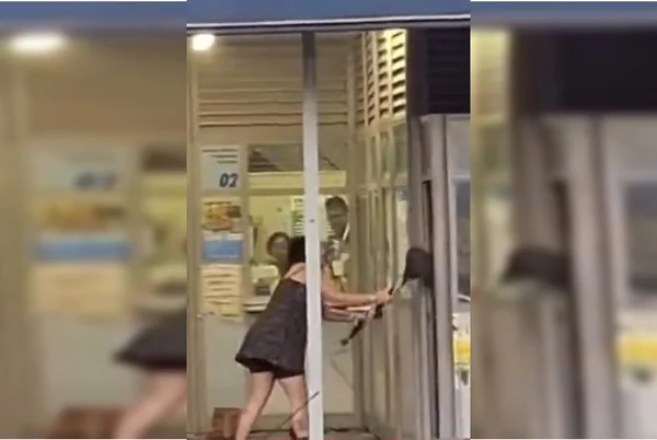 Imagem colorida de mulher destruindo uma lotérica - Metrópoles
