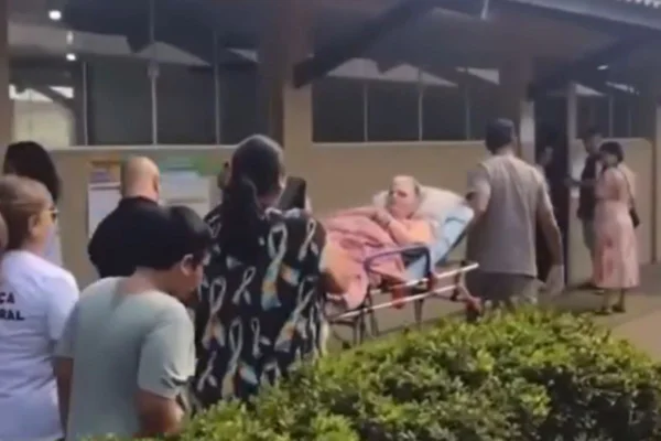 Imagem colorida de mulher de 72 anos chegando de maca em seção eleitoral - Metrópoles