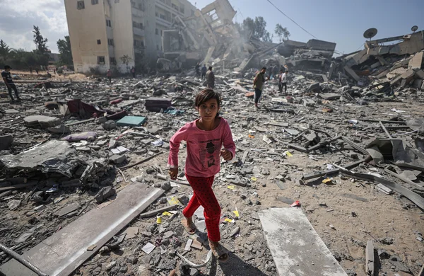 Uma menina caminha entre os escombros de edifícios residenciais após ataques aéreos israelenses no bairro de al-Zahra, na Faixa de Gaza, em 19 de outubro de 2023