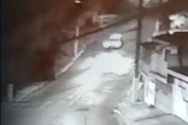 Imagem em preto e branco que mostra uma viatura perseguindo uma moto. Metrópoles