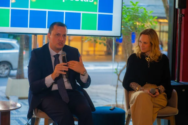 Fotografia colorida mostrando um homem e uma mulher falando em evento sobr câncer-Metrópoles
