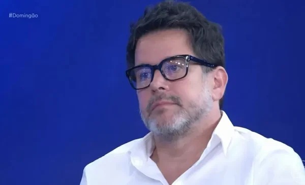 Foto colorida de Murilo Benício no Domingão com fundo azul - Metrópoles