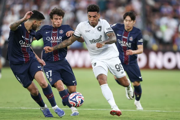 Foto colorida de Igor Jesus contra jogadores do PSG - metrópoles