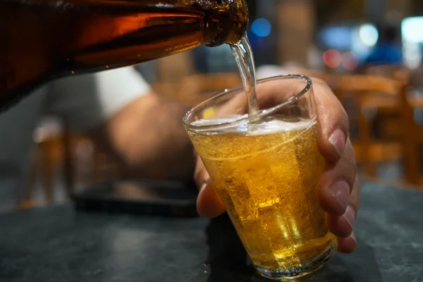 Foto colorida de copo e garrafa de cerveja - Metrópoles.