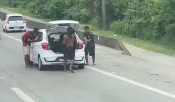 foto colorida de assaltantes atacando carros parados em congestionamento na rodovia Cônego Domênico Rangoni, no Guarujá - Metrópoles