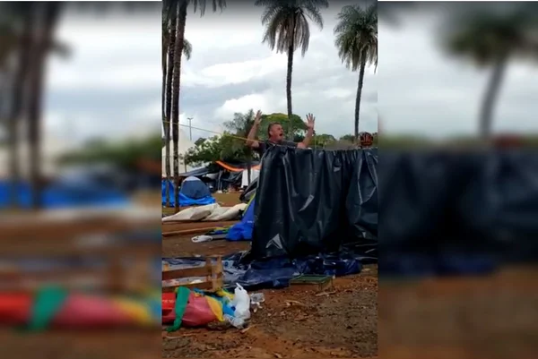Imagem colorida. Homem em pé com os braços abertos e gritando